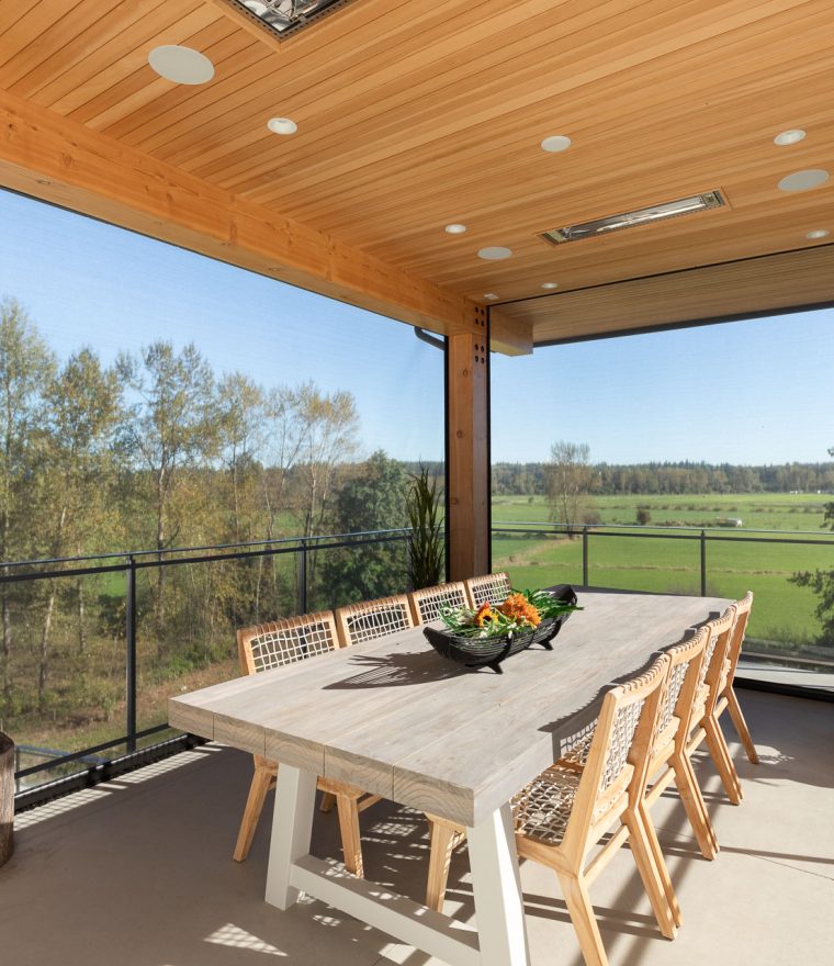 Large dining table on enclosed patio with retractable motorized screens