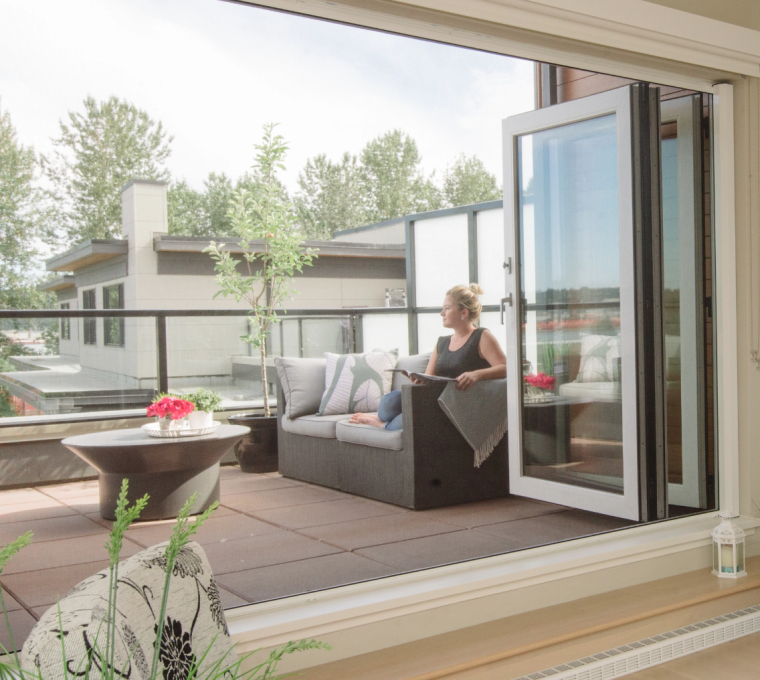 Woman sitting on balcony with retractable oversized door screens