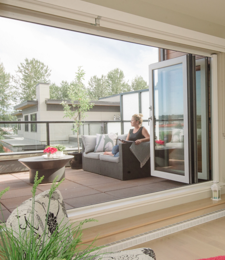 Woman sitting on balcony with retractable oversized door screens