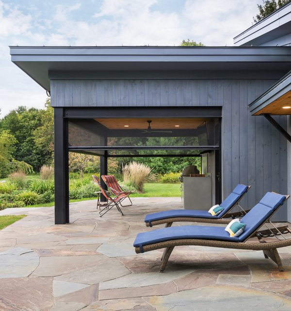 Two blue lounge chairs in front of retractable motorized screens