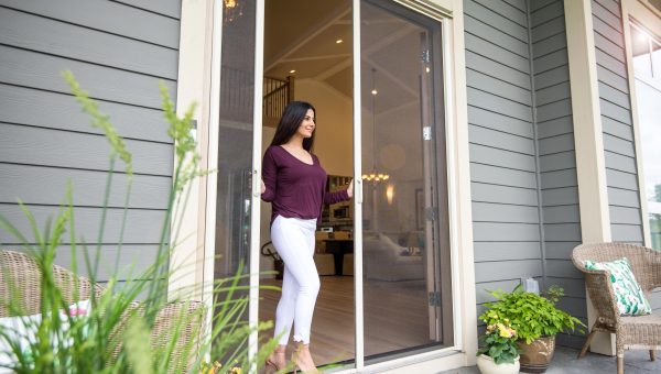 Woman stepping out of home between disappearing door screens