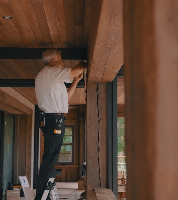 Man installation retractable motorized screens on patio