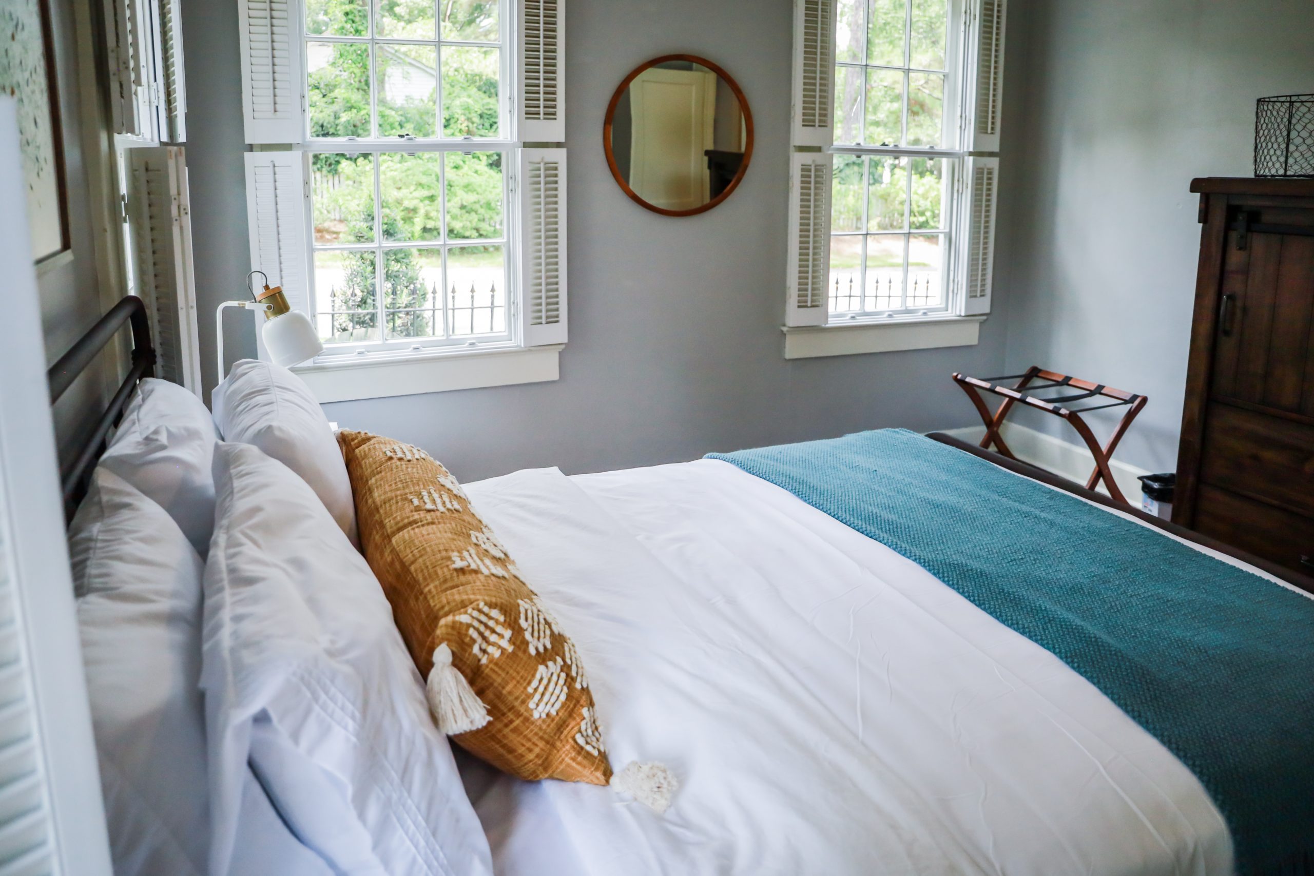 A guest bedroom with a queen sized bed and nightstand at a short term rental small cottage style house.