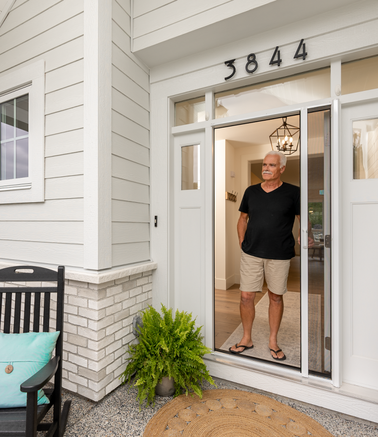 Man standing at door with retractable screen door