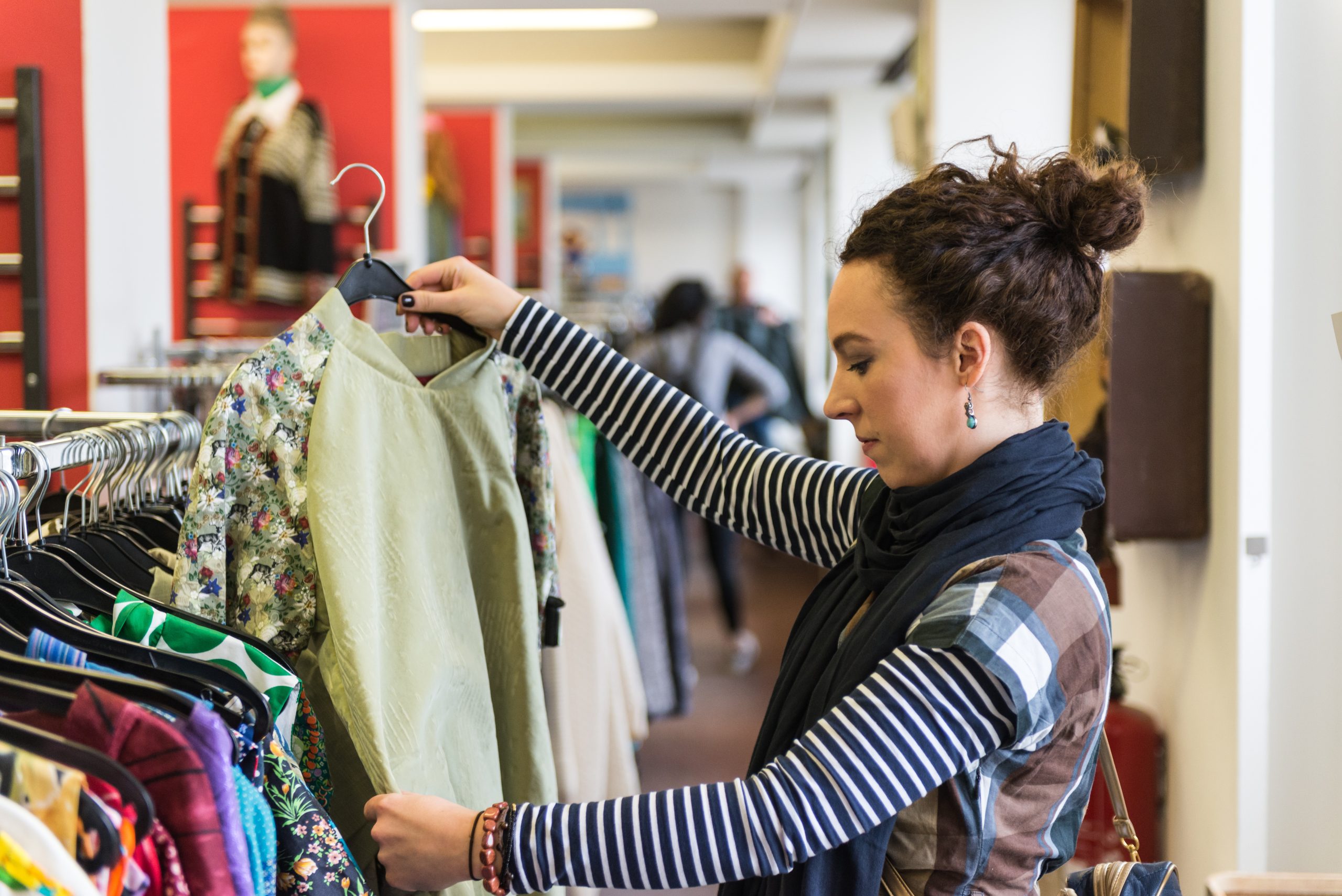 Woman looking at shirt in thrift store